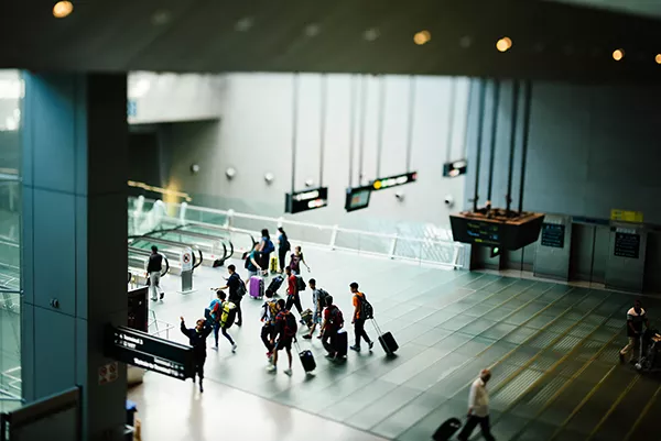 An aerial view of inside of airport, passengers walking towards departure gate