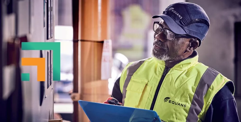 An Equans engineer in the plant room with clipboard