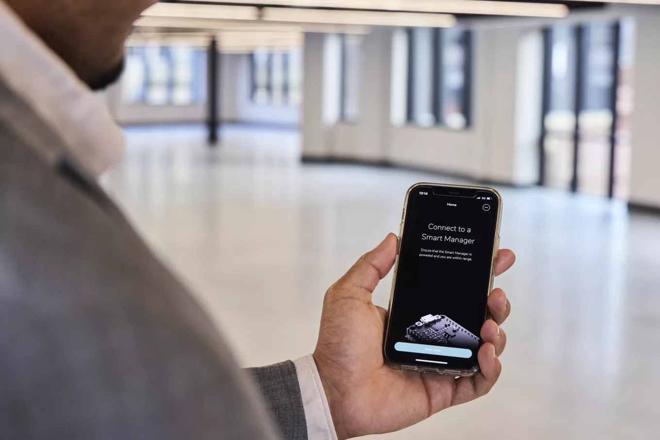 Stock image of a man holding his phone, using a smart management office app