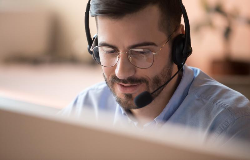 Man wearing headset in front of computer