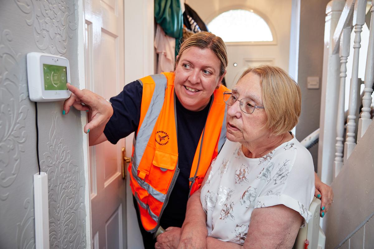 Equans employee helping resident in their home with energy savings