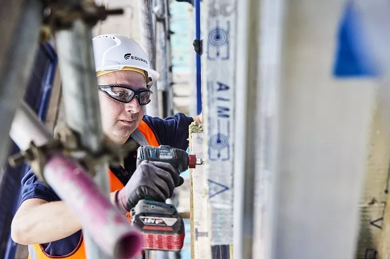 Equans employee installing wall insulation