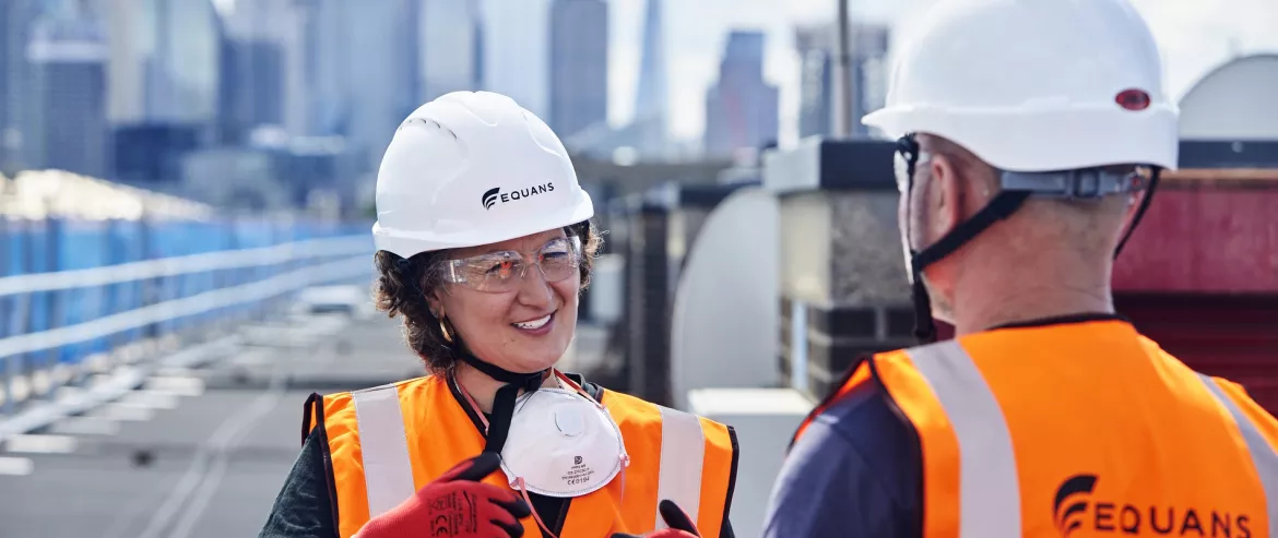 Equans employees on roof with city skyline in background