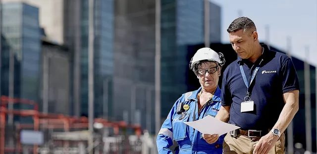 Employees collaborating in front of nuclear power station