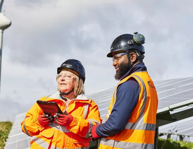 Two Equans renewables employees in ground mounted solar field
