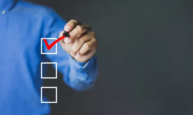 Businessman checking mark on the check boxes with red marker