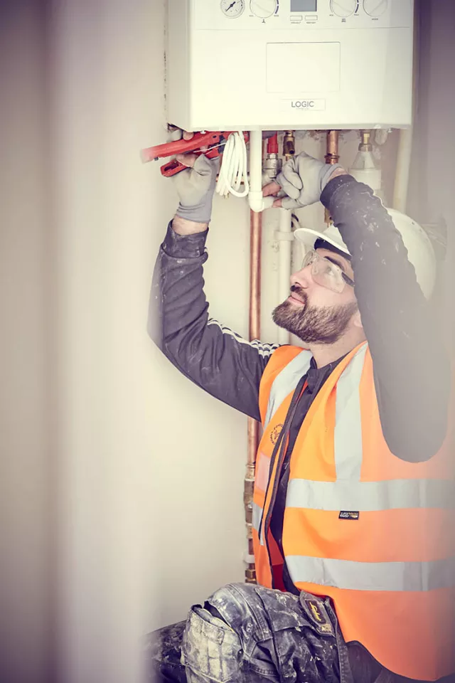 An equans employee checking a boiler