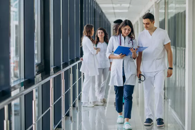 Student nurses walking through corridor of hospital