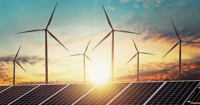 An image of renewable energy including wind turbines and solar panels