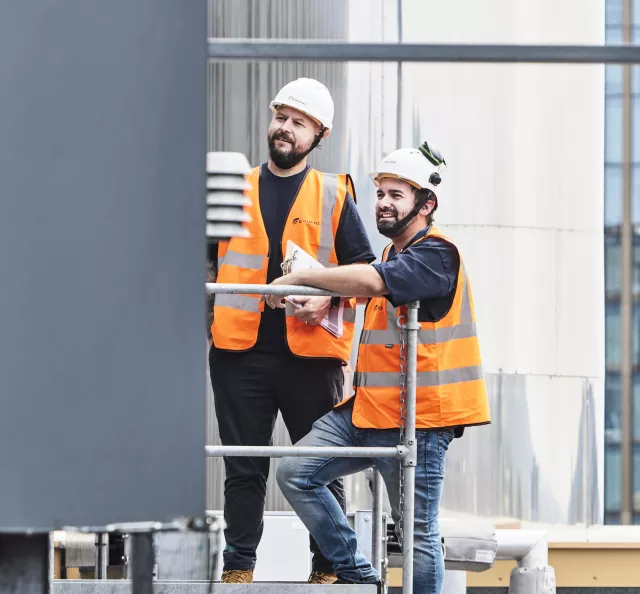 Two Equans district energy employees inspecting plant