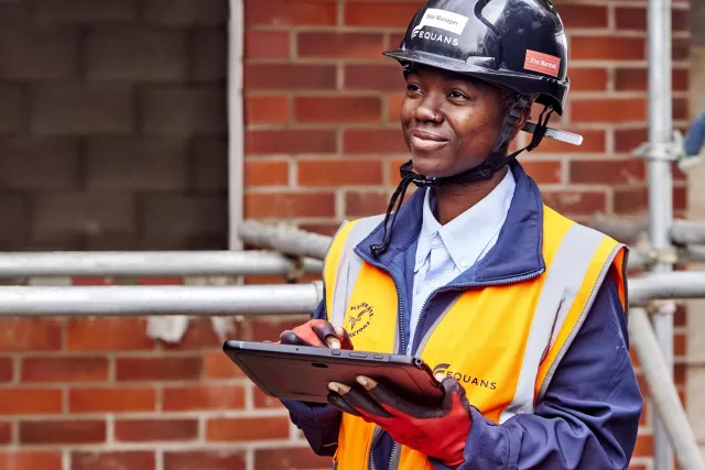 Equans site manager on building site using tablet pc