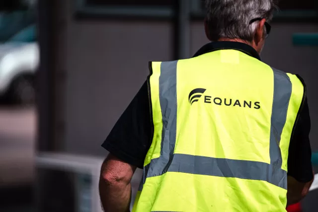 Back of employee wearing Equans hi vis