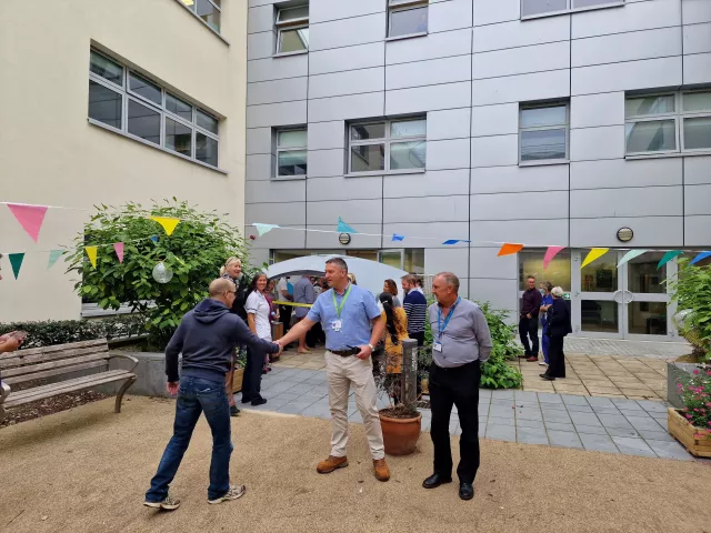 Two people shaking hands outside hospital