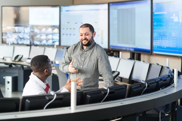 Equans operatives collaborating by digital data screens