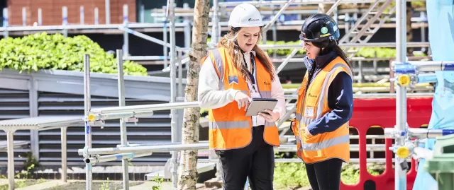 Two Equans employees collaborating on a construction site